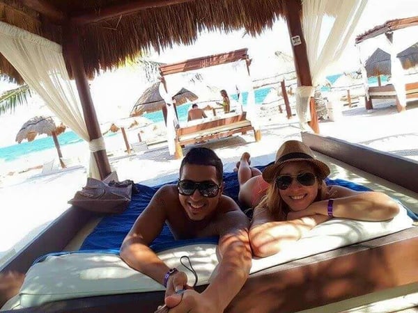 Couple takes photo with selfie stick while on the beach.