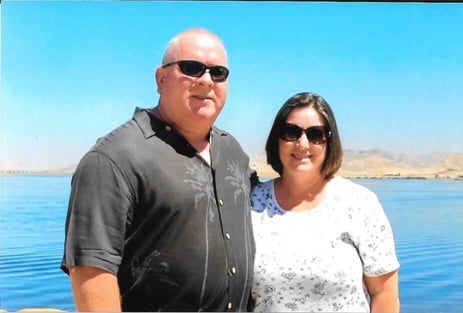 Man and wife stand in front of the ocean.